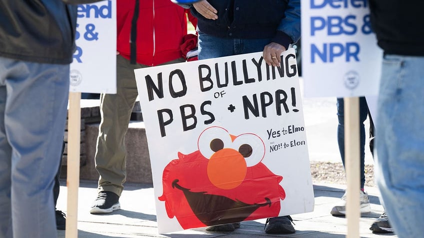 People participate in a rally to call on Congress to protect funding for public broadcasters outside the NPR headquarters in Washington, DC.