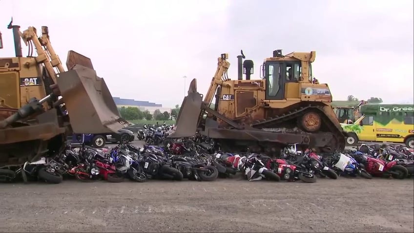 bulldozers driving over mopeds and scooters