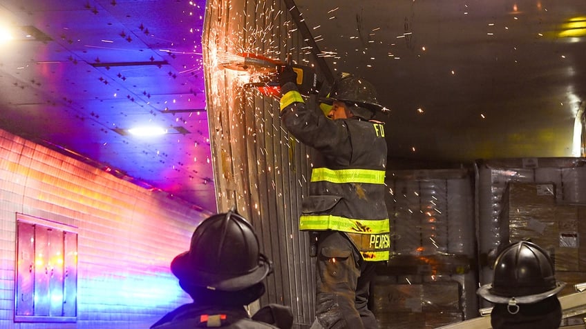 nyc firefighters seen cutting apart truck that got wedged in tunnel causing traffic nightmare