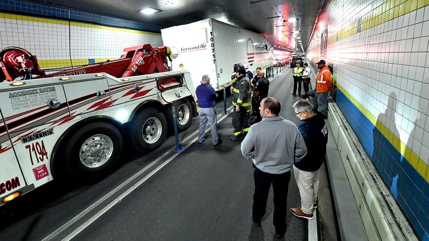 nyc firefighters seen cutting apart truck that got wedged in tunnel causing traffic nightmare