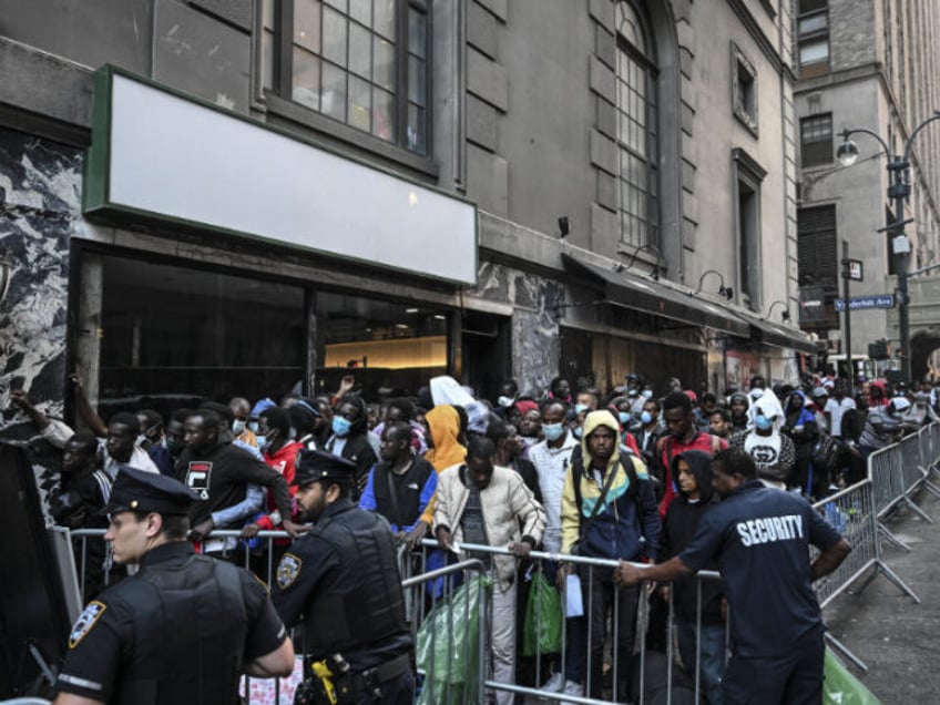 Police officers take security measures during migrants line up outside Roosevelt Hotel whi