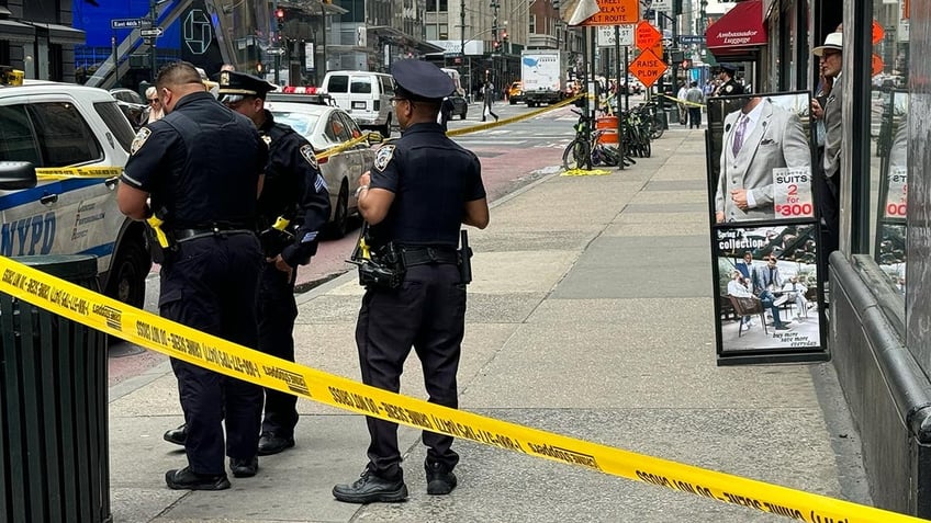 Police behind crime scene tape on the street in New York City