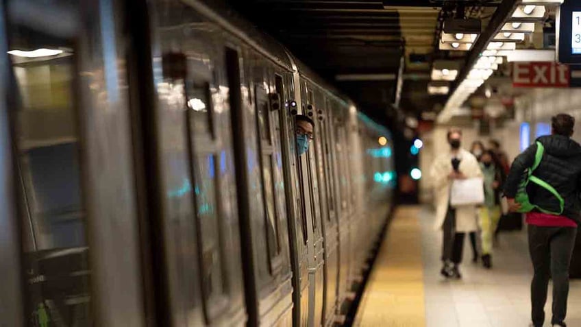 subway conductor peeking out of cabin at station