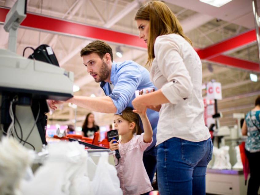 Couple with one child checking out at the supermarket.