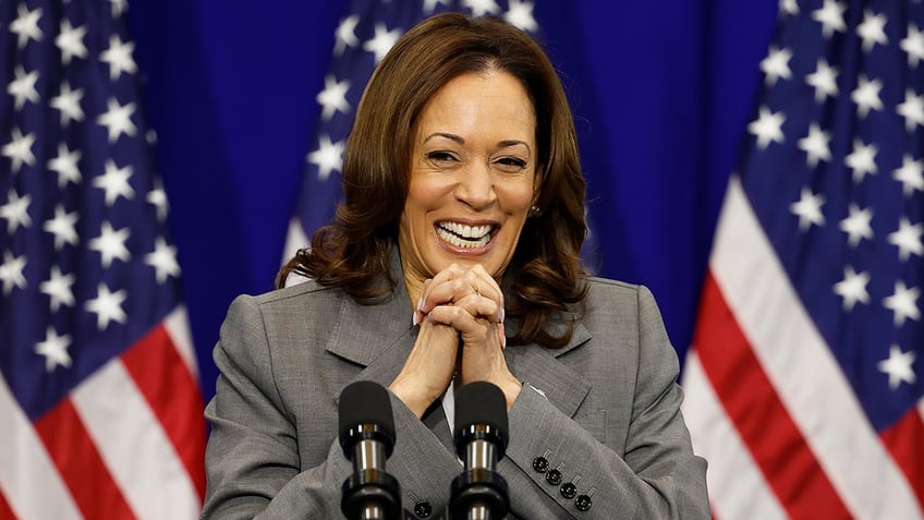 closeup Kamala Harris with US flags behind her