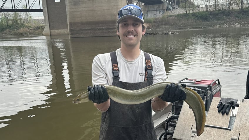 Liam Odell holding an eel found in KS river