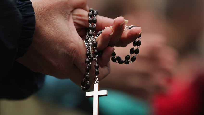 Rosary held by hands.