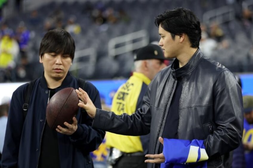 Baseball star Shohei Ohtani talks with his interpreter Ippei Mizuhara before an NFL footba