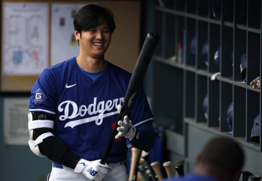 Los Angeles Dodgers superstar Shohei Ohtani of Japan smiles as he warms up for an exhibiti