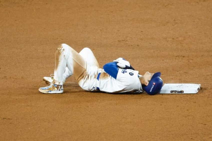 Los Angeles Dodgers star Shohei Ohtani lies on the ground after injuring his shoulder atte