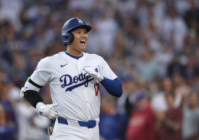 Shohei Ohtani of the Los Angeles Dodgers reacts after hitting a solo home run in a game ag