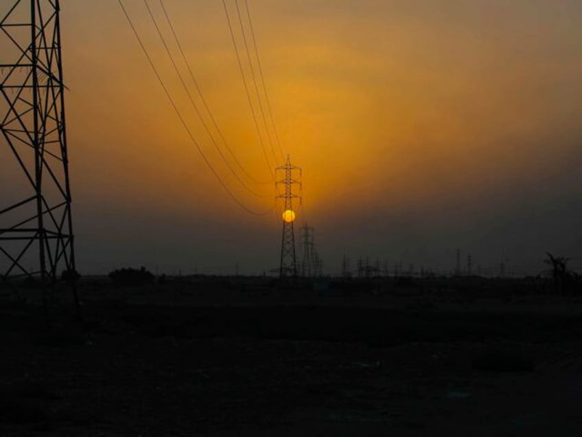 The sun sets behind the transmission lines of electric power from Iran to Iraq in Basra, I