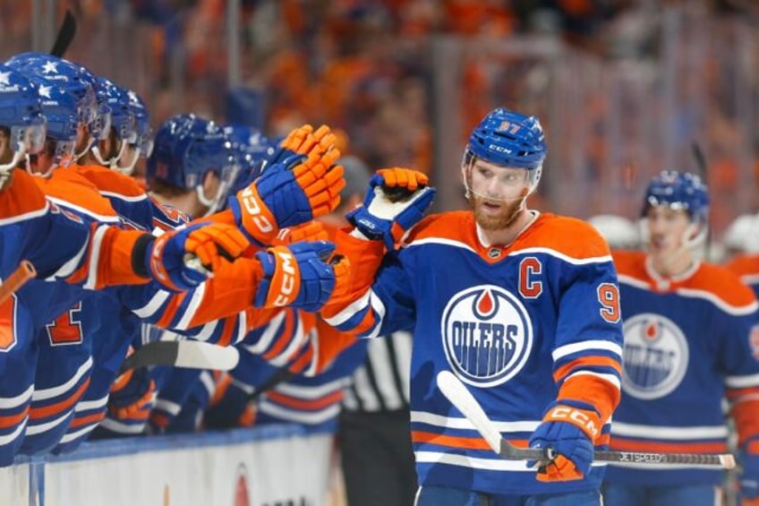 Edmonton's Connor McDavid celebrates a power play goal with teammates on the bench as the