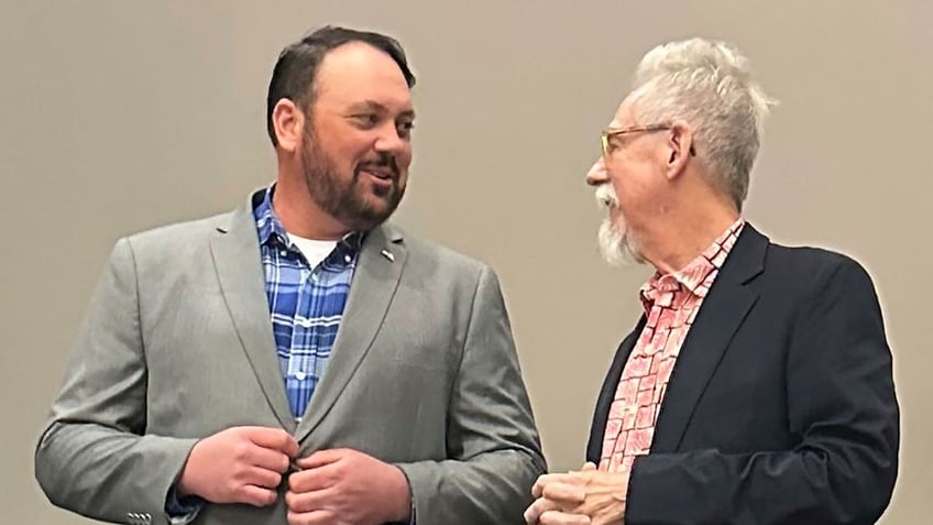 Judd Blevins, left, a city councilor in Enid, Oklahoma, speaks to Enid resident Frank Baker