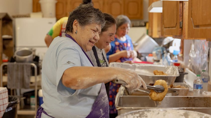 Carol Tiger, a member of Muscogee Nation and an elder at the Springfield United Methodist Church in Okemah, Oklahoma, lets the oil drip off a freshly-cooked piece of frybread