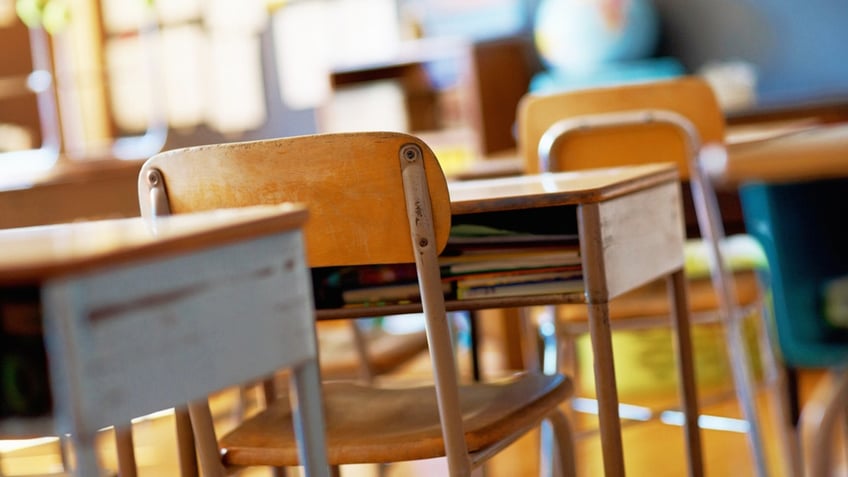 empty desks in classroom in stock photo