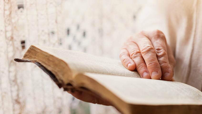 Bible being read, hands shown