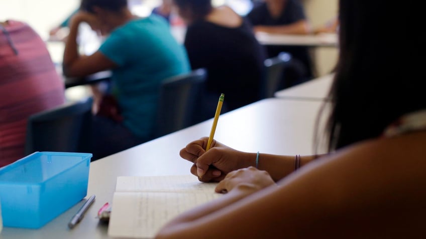 STUDENT WRITING IN CLASS