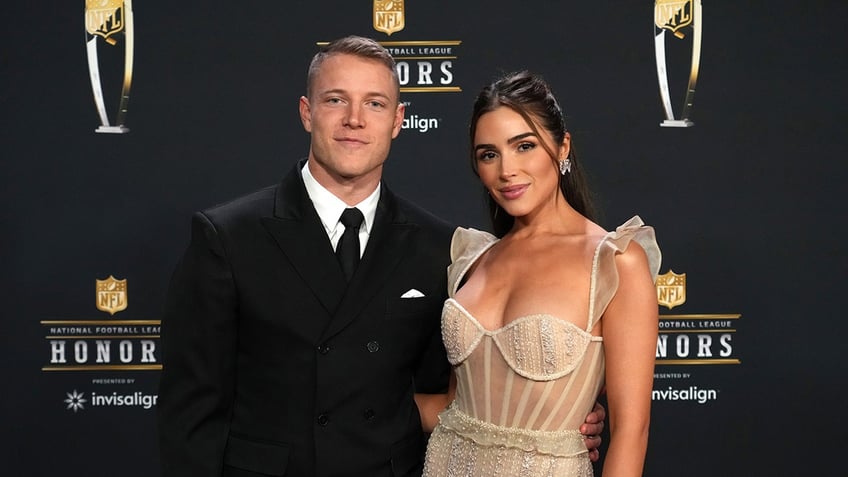 Christian McCaffrey and Olivia Culpo poses on red carpet