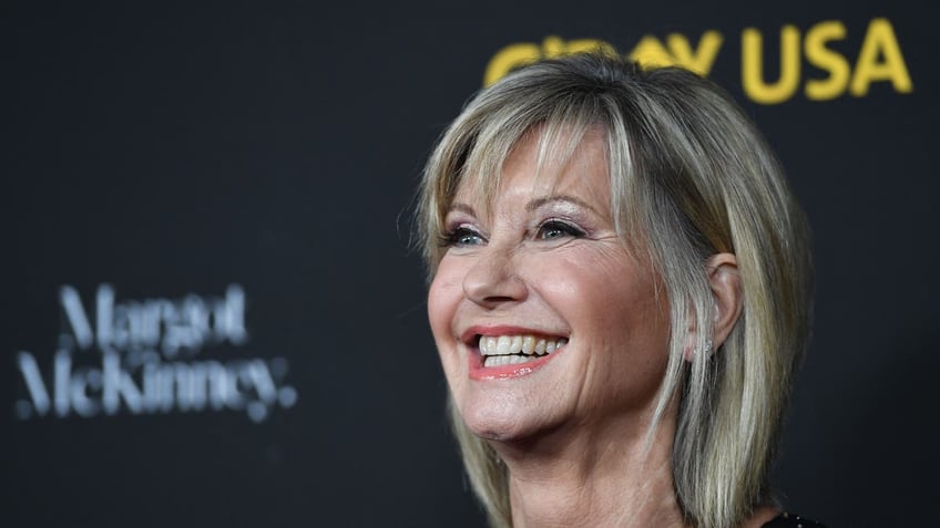 Olivia Newton-John beams at a red carpet event