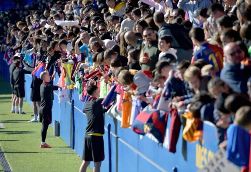 Barcelona's Spanish forward Dani Olmo and teammates sign autographs for fans at an open tr