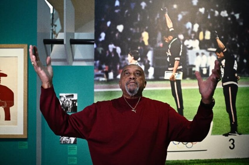 Tommie Smith poses in front of the emblematic photograph of the 1968 Mexico City Olympics