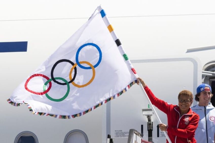 Los Angeles Mayor Karen Bass held the five-ringed Olympic banner, accompanied by several U