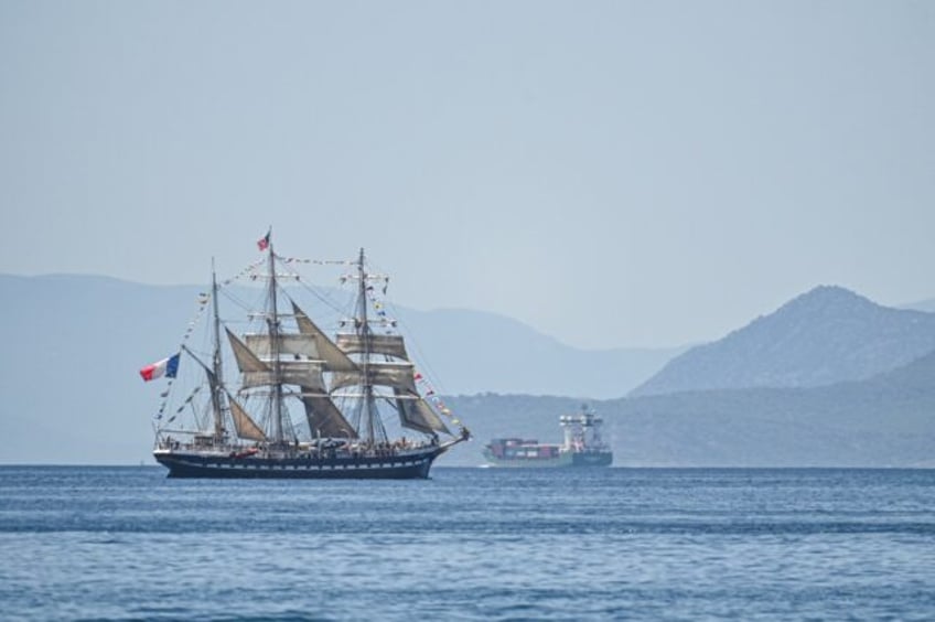 The Olympic flame is being brought to France from Greece on a 19th-century tall ship