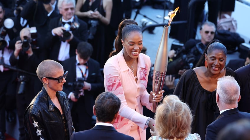 The Olympic torch appears on the Cannes red carpet
