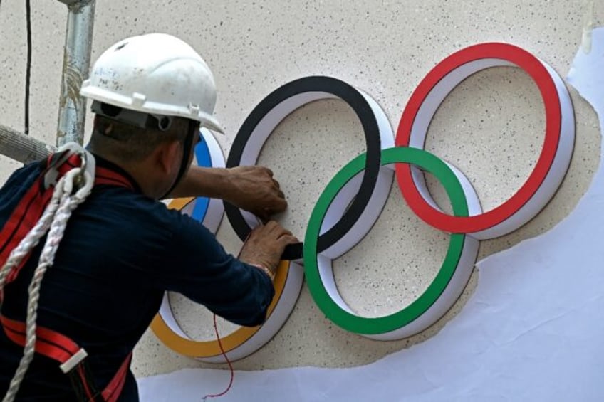 A labourer fixes the Olympic signage ahead of an IOC session in Mumbai last year