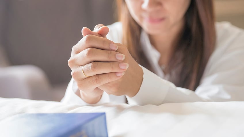 Woman praying at her bed