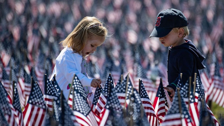 Children playing, surrounded by flags.