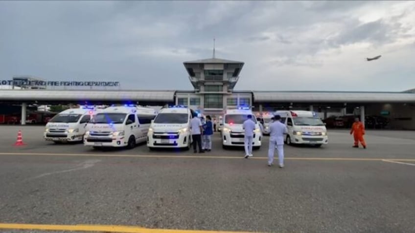 Medical staff gather at Suvarnabhumi Airport in Bangkok after a Singapore Airlines flight