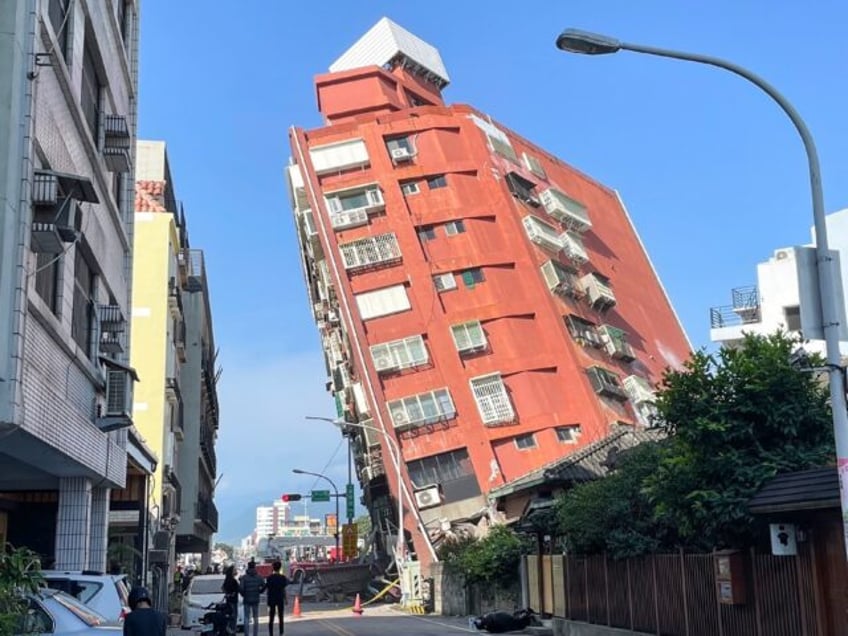 A Taiwan's Central News Agency photo shows people looking at a damaged building in Hualien