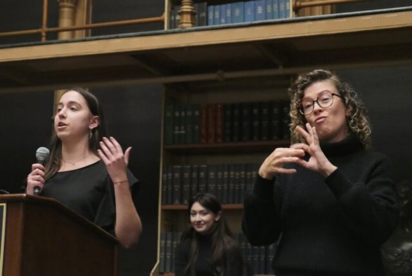 An interpreter signs in American Sign Language during a debate between Gallaudet Universit