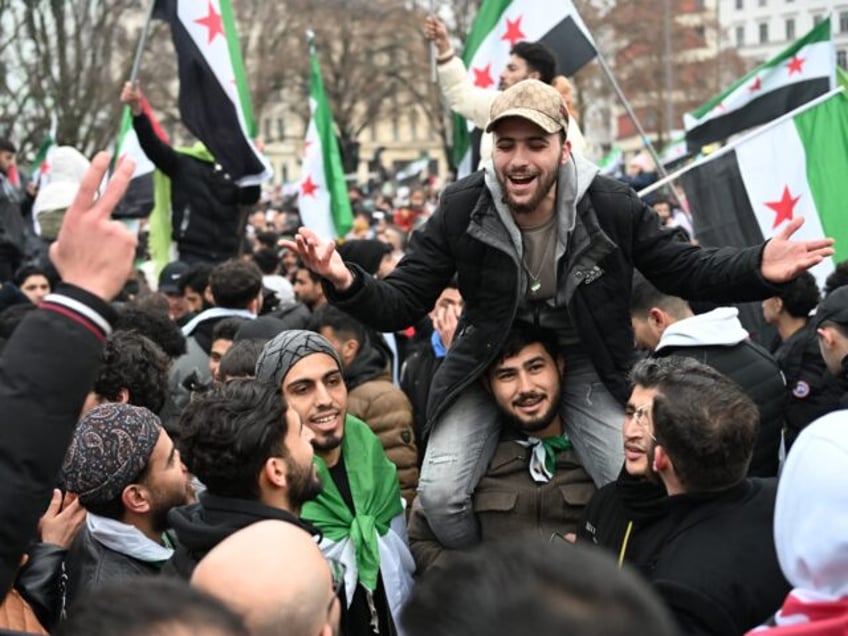 Members of the Syrian community wave Syrian flags on December 8, 2024 in Berlin, Germany,