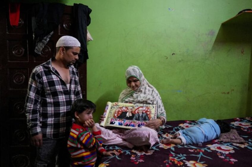 The mother of Faheem Qureshi, who was killed in anti-Muslim riots in February, sits with a