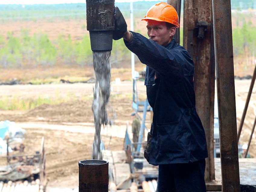 RUSSIA - SEPTEMBER 22: Bore fluid gushes from a well on an oil derrick in the Lukoil owned