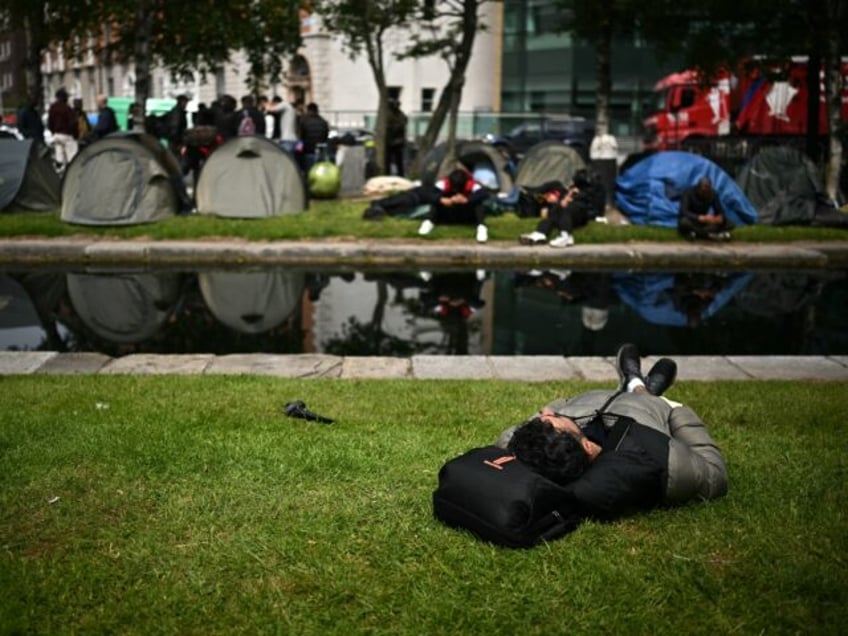 TOPSHOT - Tents are pictured at a makeshift camp, set up by migrants along the banks of th