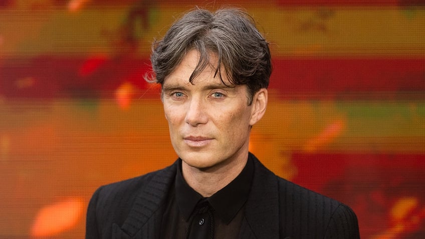 Cillian Murphy smirks subtly on the carpet in all black for 'Oppenheimer'