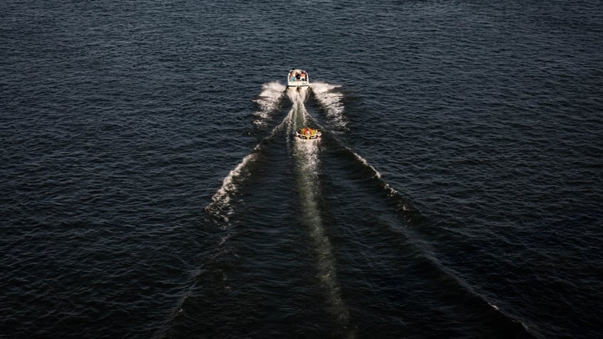 A speedboat pulls tubers on the Willamette River during a heatwave in Portland, Oregon, U.S., on Monday, June 28, 2021.