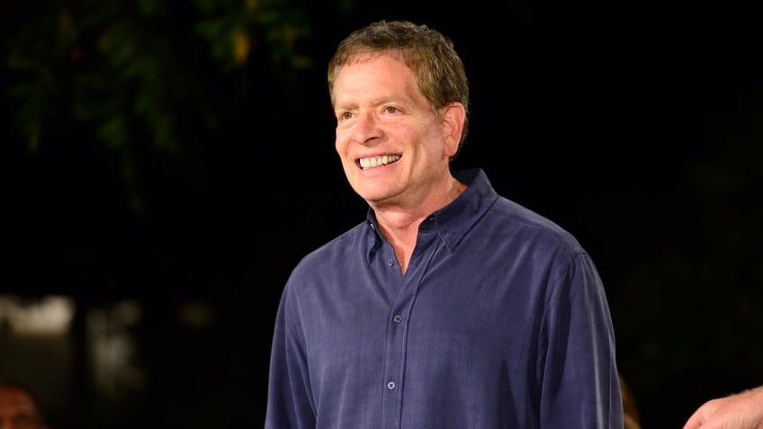 David Zucker smiles in a navy blue button down