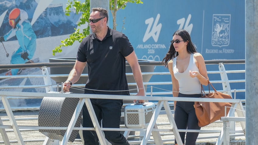 Kendall Jenner walks dock wearing cream tank top and slacks.
