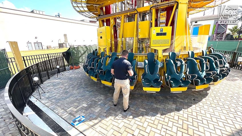 A man conducts an inspection of a theme park ride.