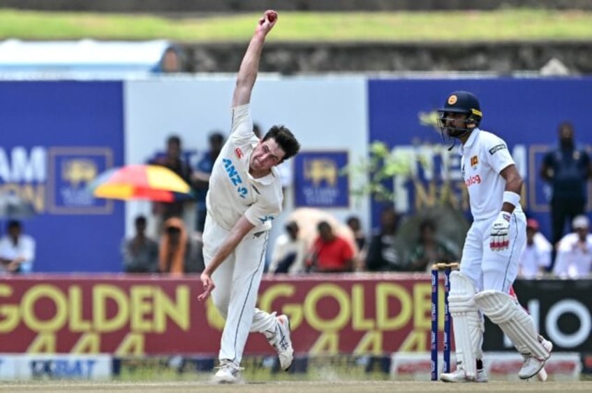 New Zealand's William O’Rourke bowls as Sri Lanka's Dinesh Chandimal watches during the