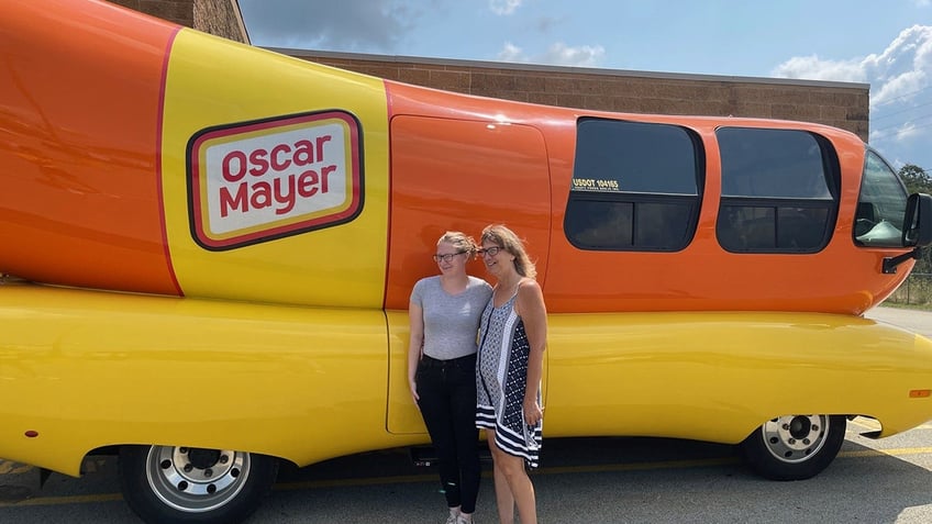 People take picture in front of Oscar Mayer hot dog car