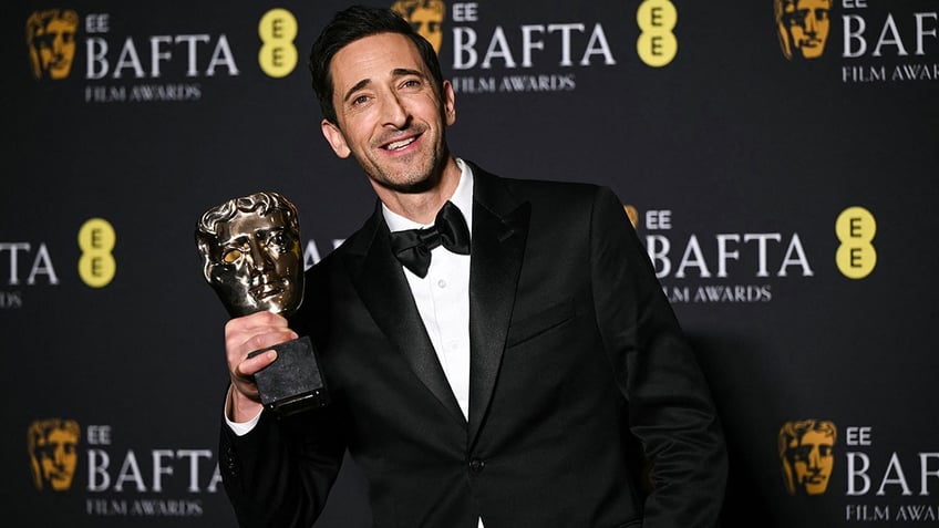 Adrien Brody posing with his BAFTA Award at the BAFTAs