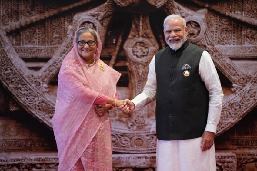 India's Prime Minister Narendra Modi shakes hands with Sheikh Hasina, then Bangladesh's pr