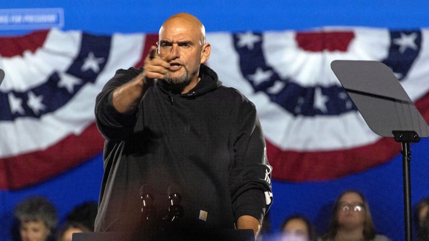 Fetterman points on stage at a Harris campaign rally