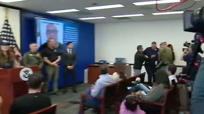 Padilla at right being detained at Noem event